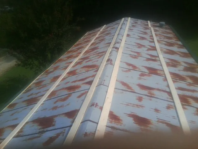Rusted metal roof panels with new wood purlins before replacement — Storm Damage Roof Repair in Woosung by Roofing Brothers