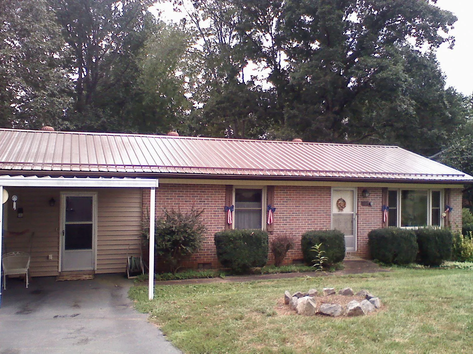 Bronze metal roof and carport on a brick ranch home — Roof Repair work by our crew in Woosung